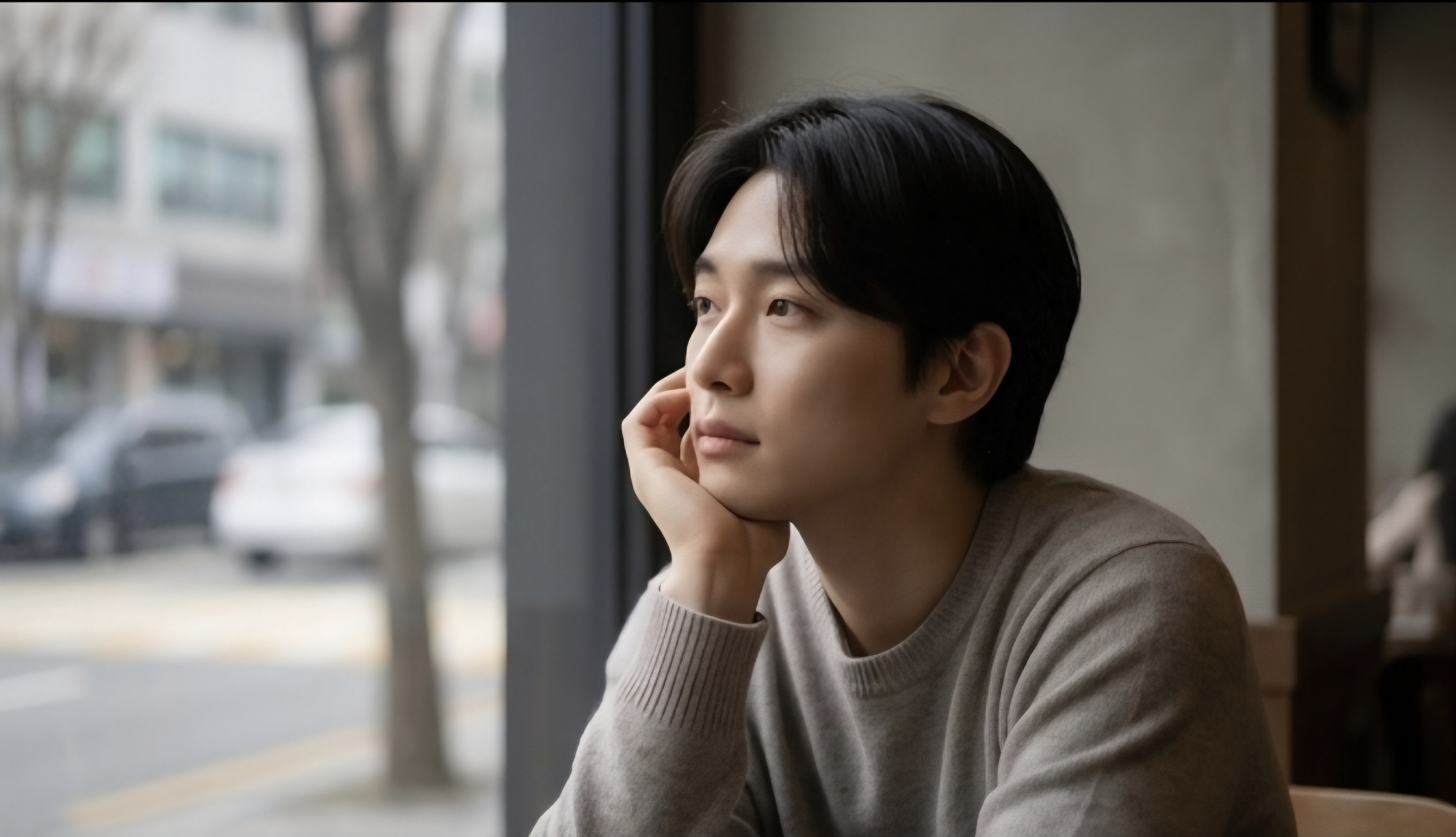 A man alone by a café window